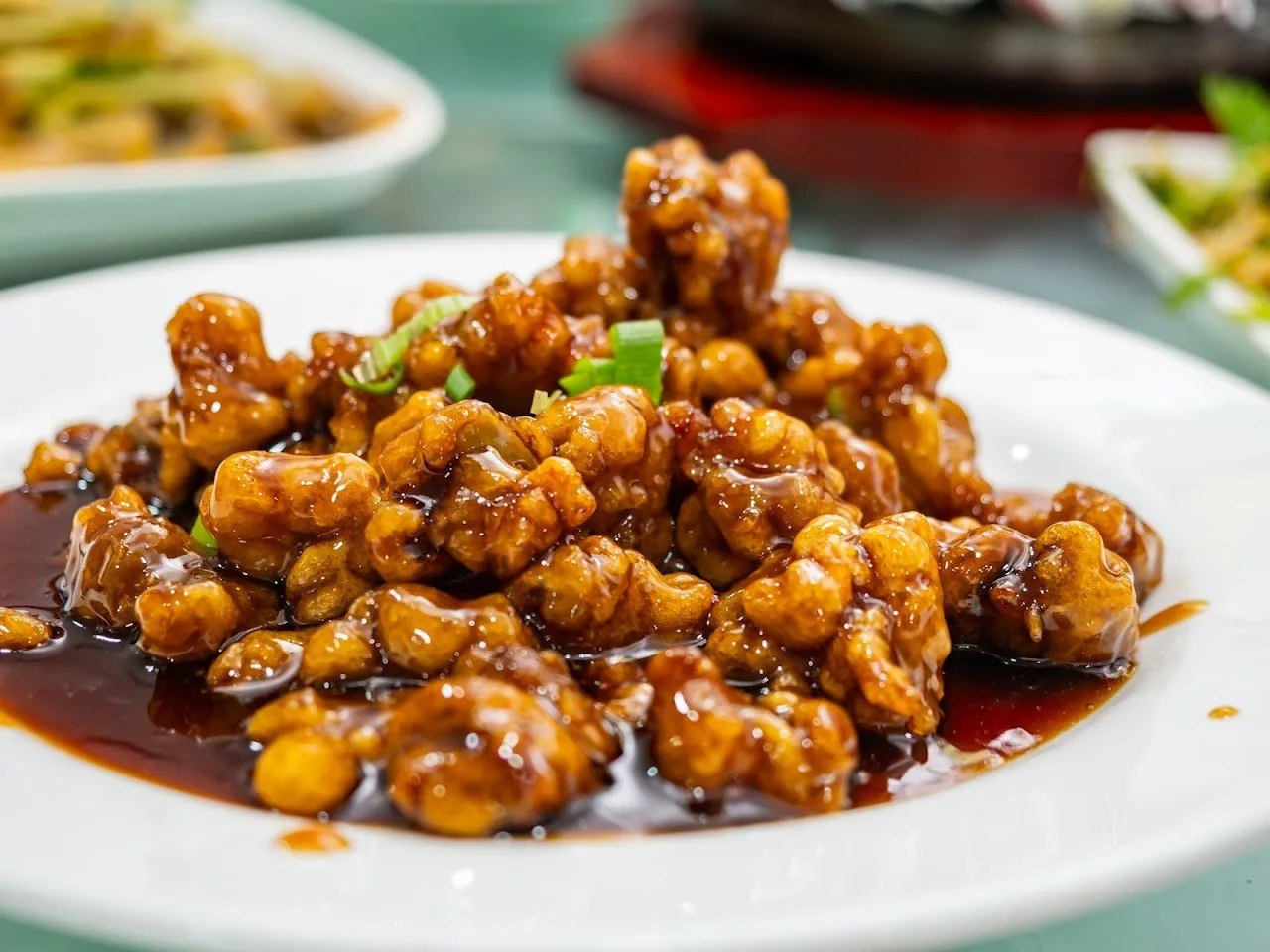 A plate of golden crispy chicken pieces with spring onion