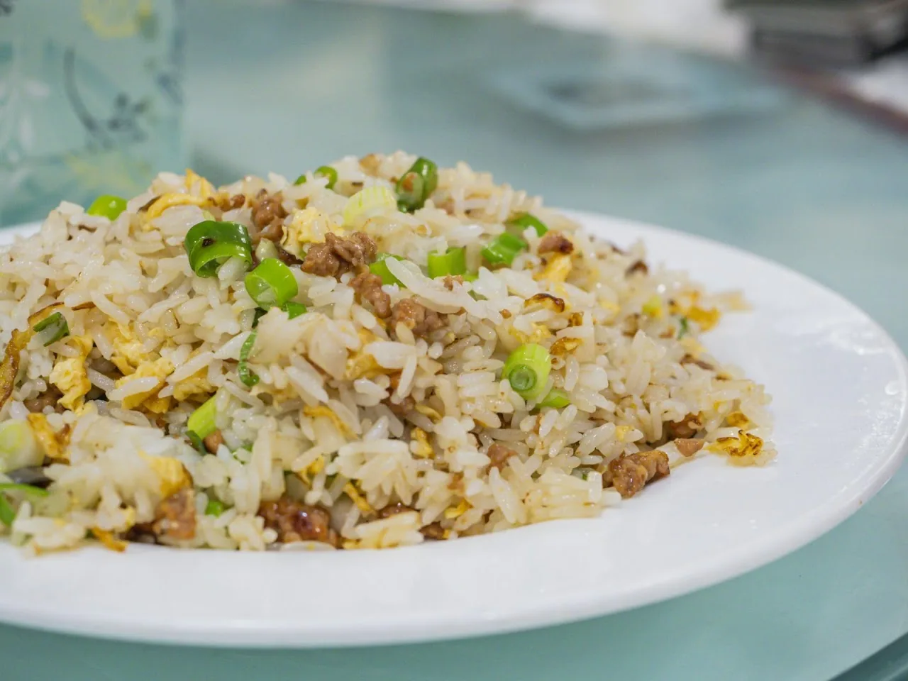 A plate of fried rice with scrambled egg and scallions