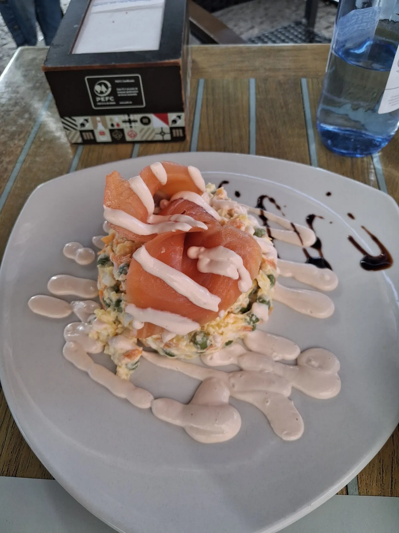 A plate of jamón and salad with a creamy dressing drizzle