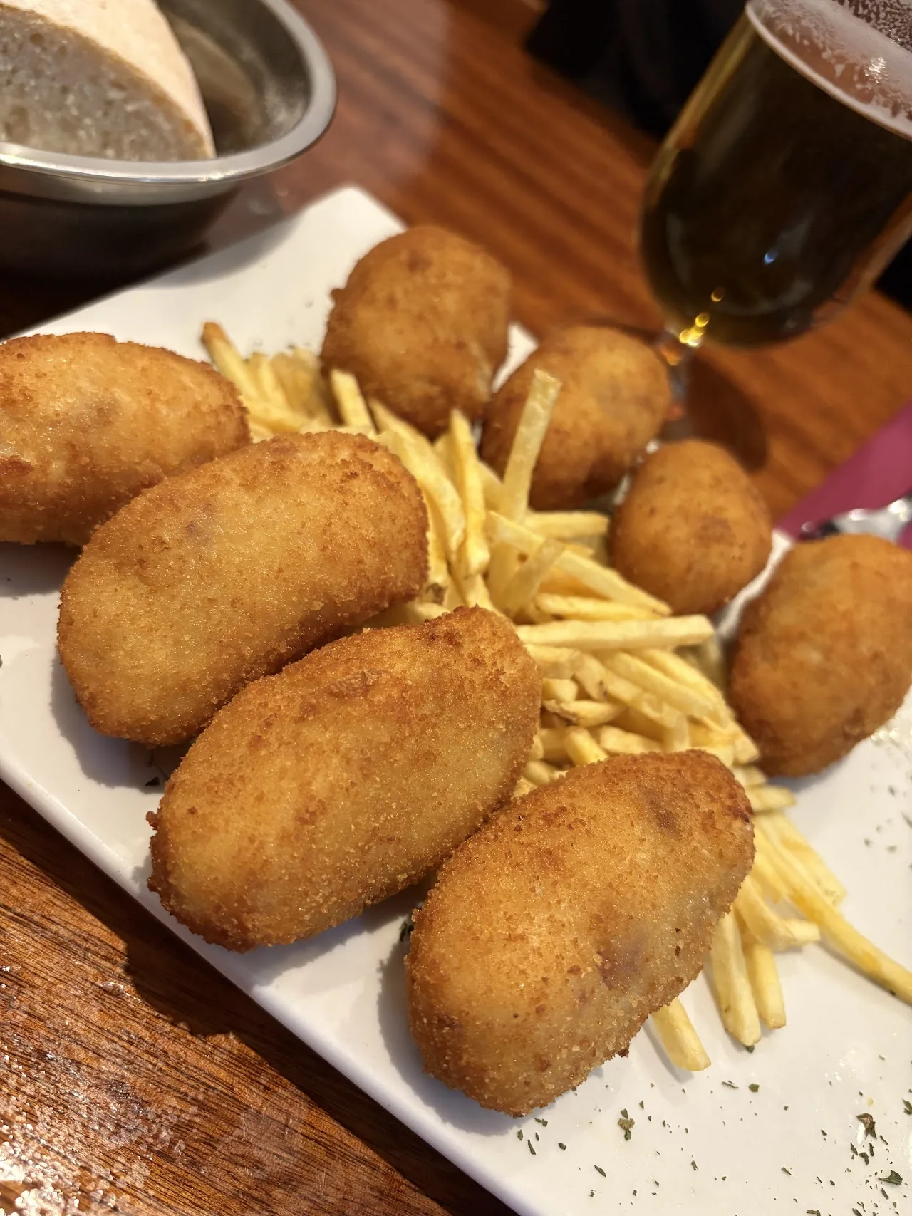 A plate of breaded croquettes with french fries