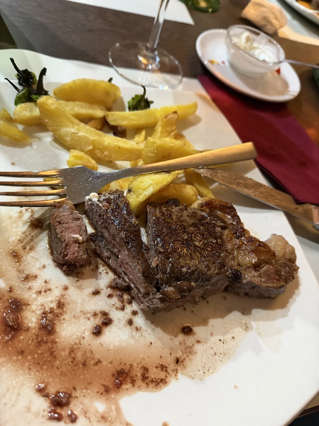 A grilled steak with a side of fried potatoes