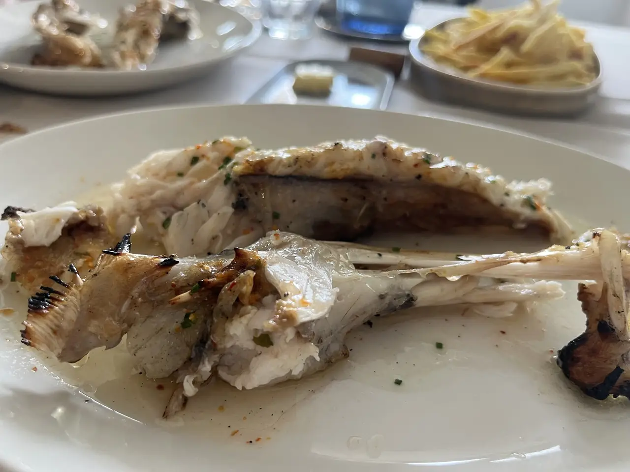 Grilled whole fish filleted tableside on a white plate