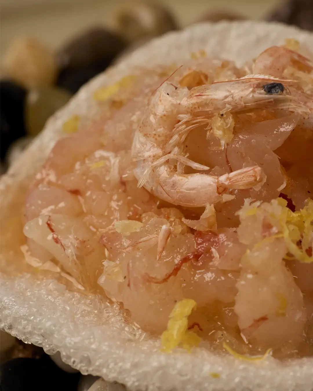 Close-up of raw shrimp with citrus zest served on ice