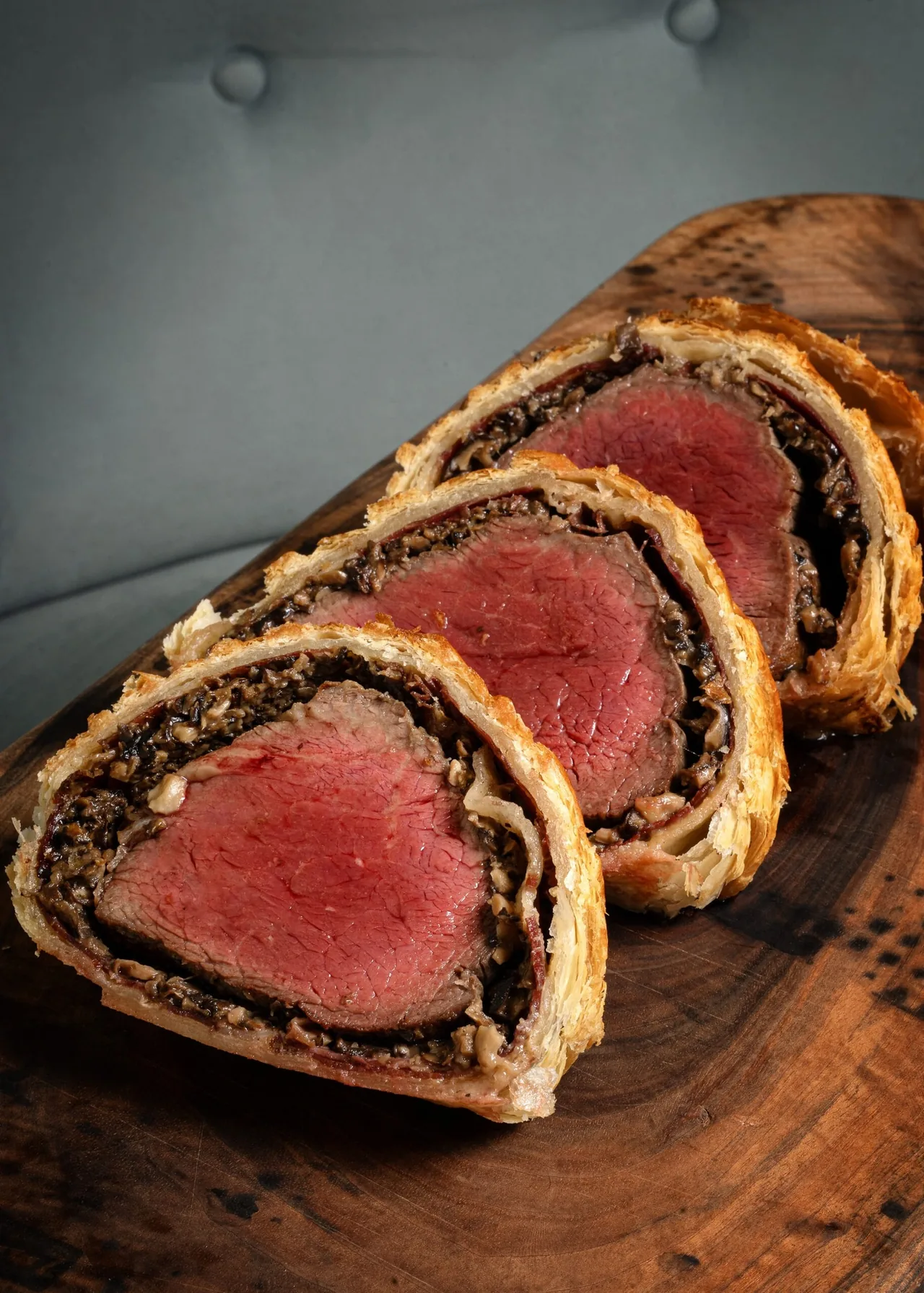 Slices of beef in a pastry crust on a wooden board