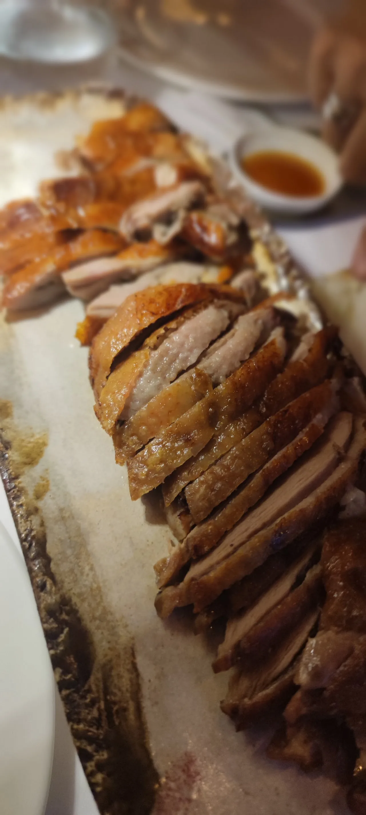 Sliced roast duck with crispy skin on a platter