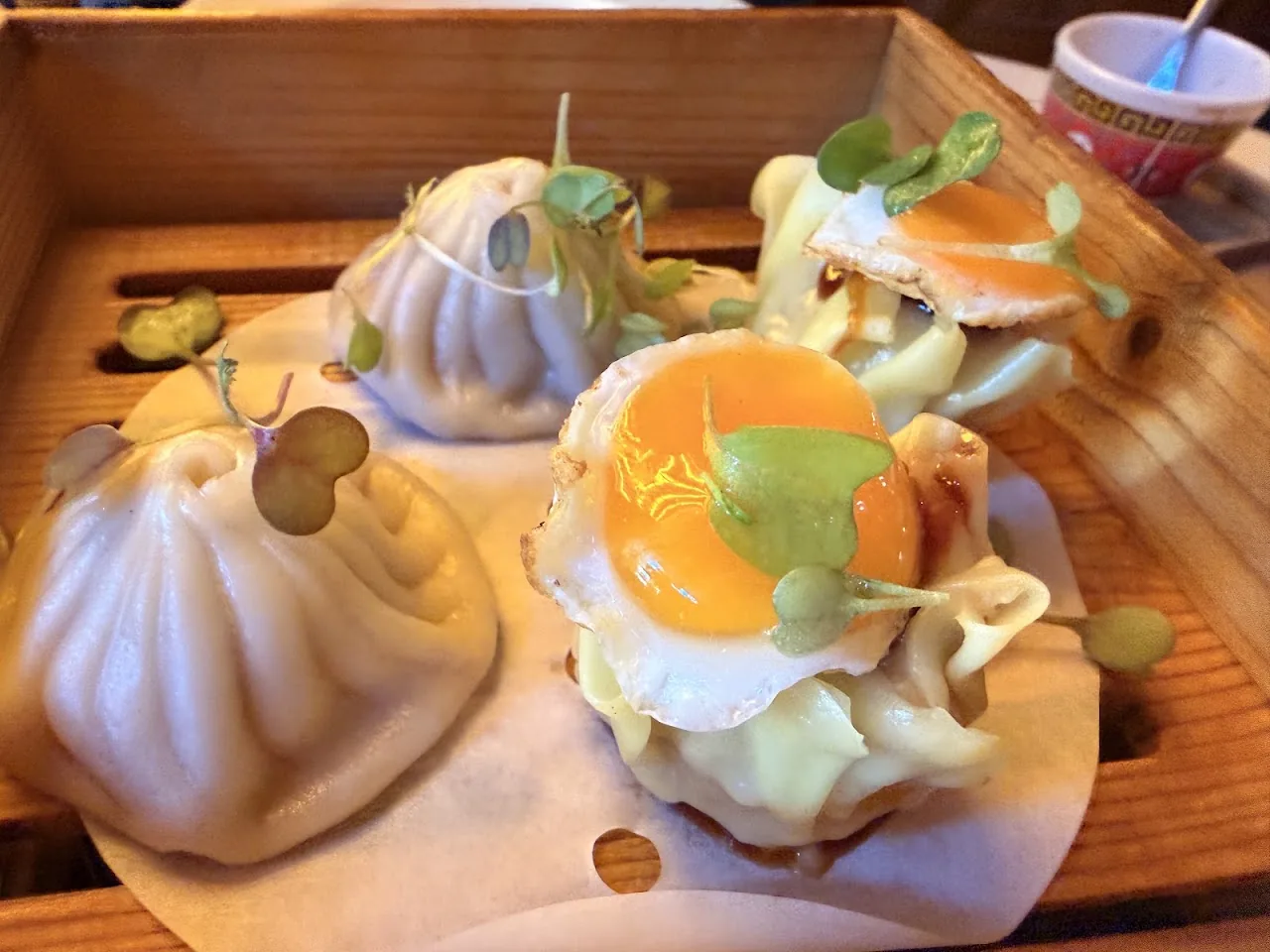 Dumplings topped with a fried egg and microgreens