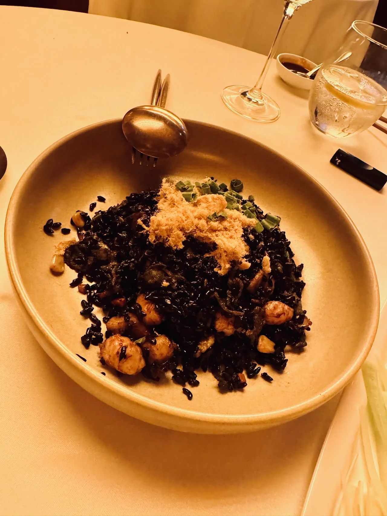 A bowl of fried rice or grains topped with truffle shavings