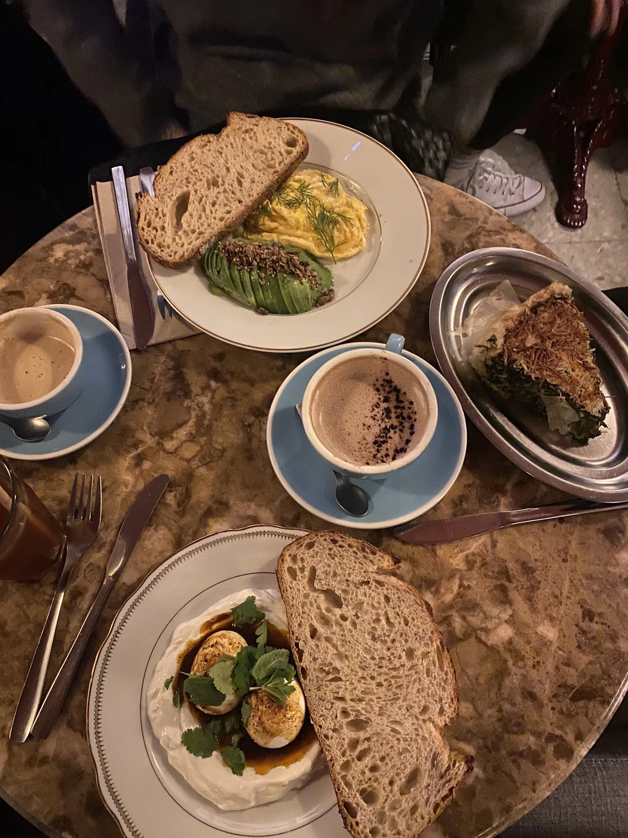 Toasts, coffees, and small plates arranged on a table