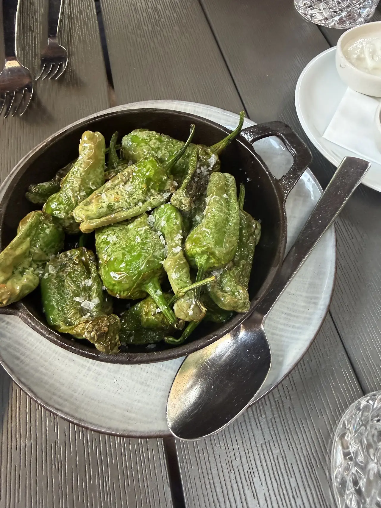 Blistered padron peppers with sea salt in a small cast-iron pot