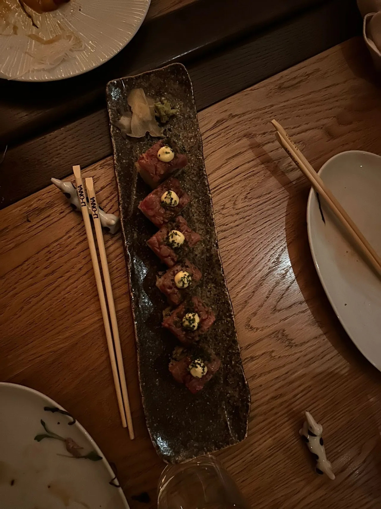 A tray of assorted sushi rolls with chopsticks