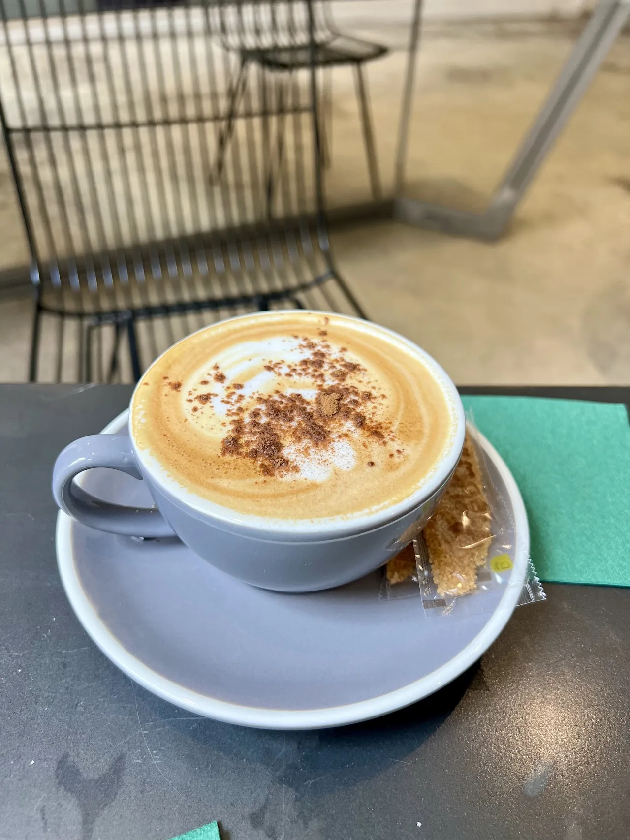A cappuccino dusted with cinnamon in a blue cup