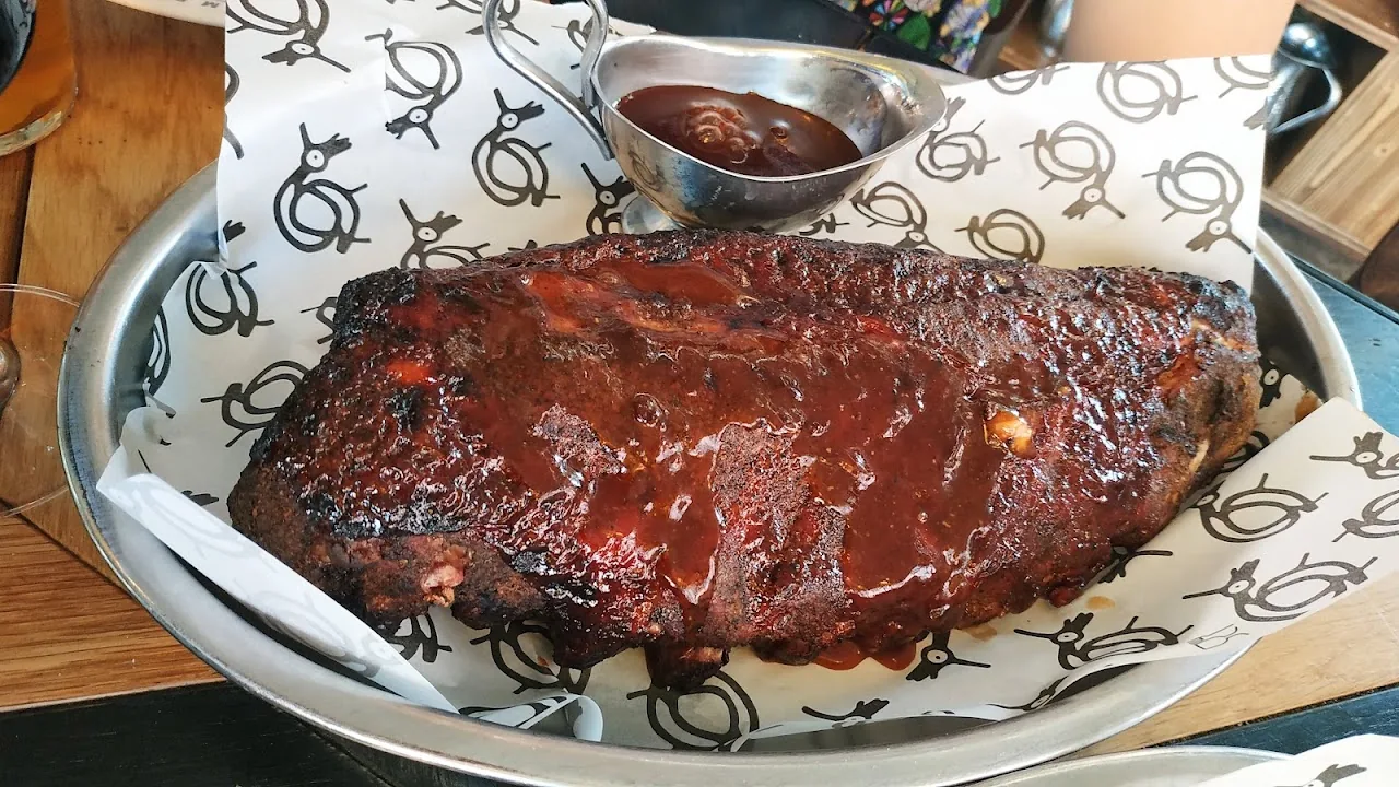 A rack of glazed barbecue ribs on a tray
