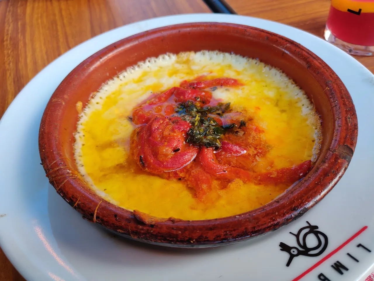 A terracotta dish of baked eggs in tomato sauce