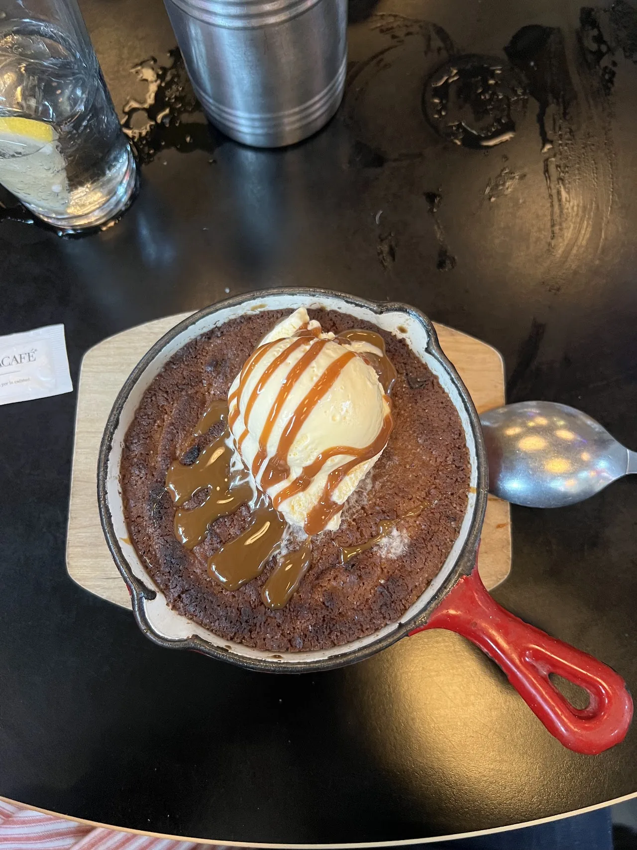 A skillet chocolate dessert topped with a scoop of ice cream