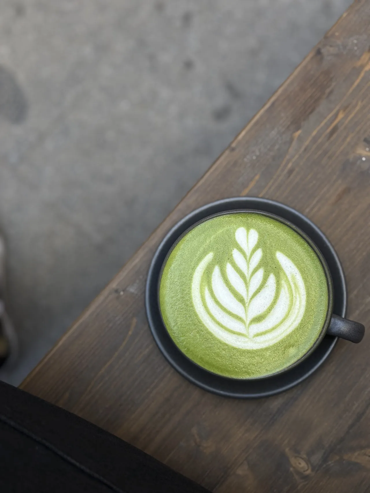 A matcha latte with leaf-pattern latte art