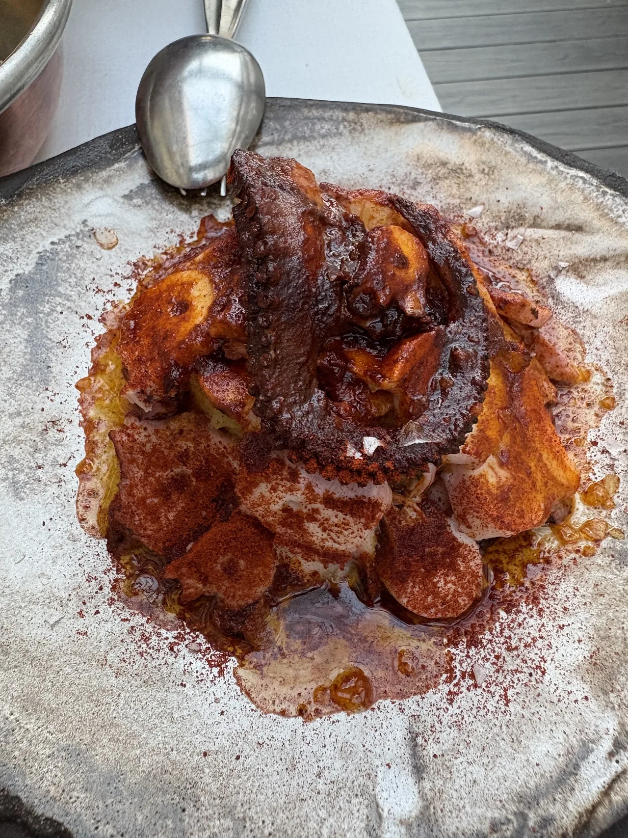 A plate of grilled octopus with paprika and crispy bits
