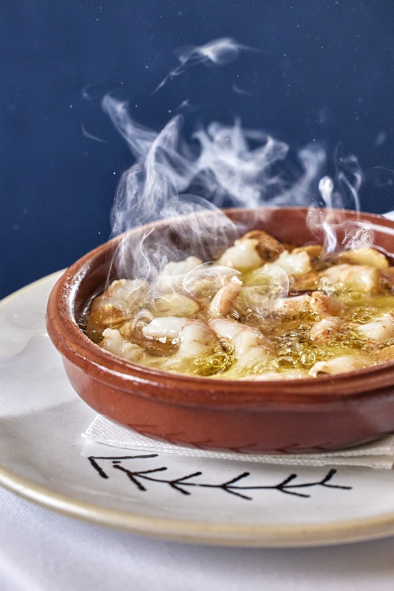 A steaming clay dish of garlic shrimp