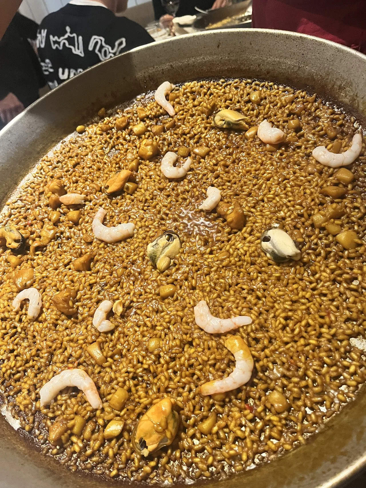 A pan of seafood paella with shrimp and mussels