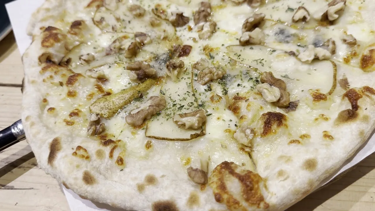 A white pizza topped with mushrooms and herbs