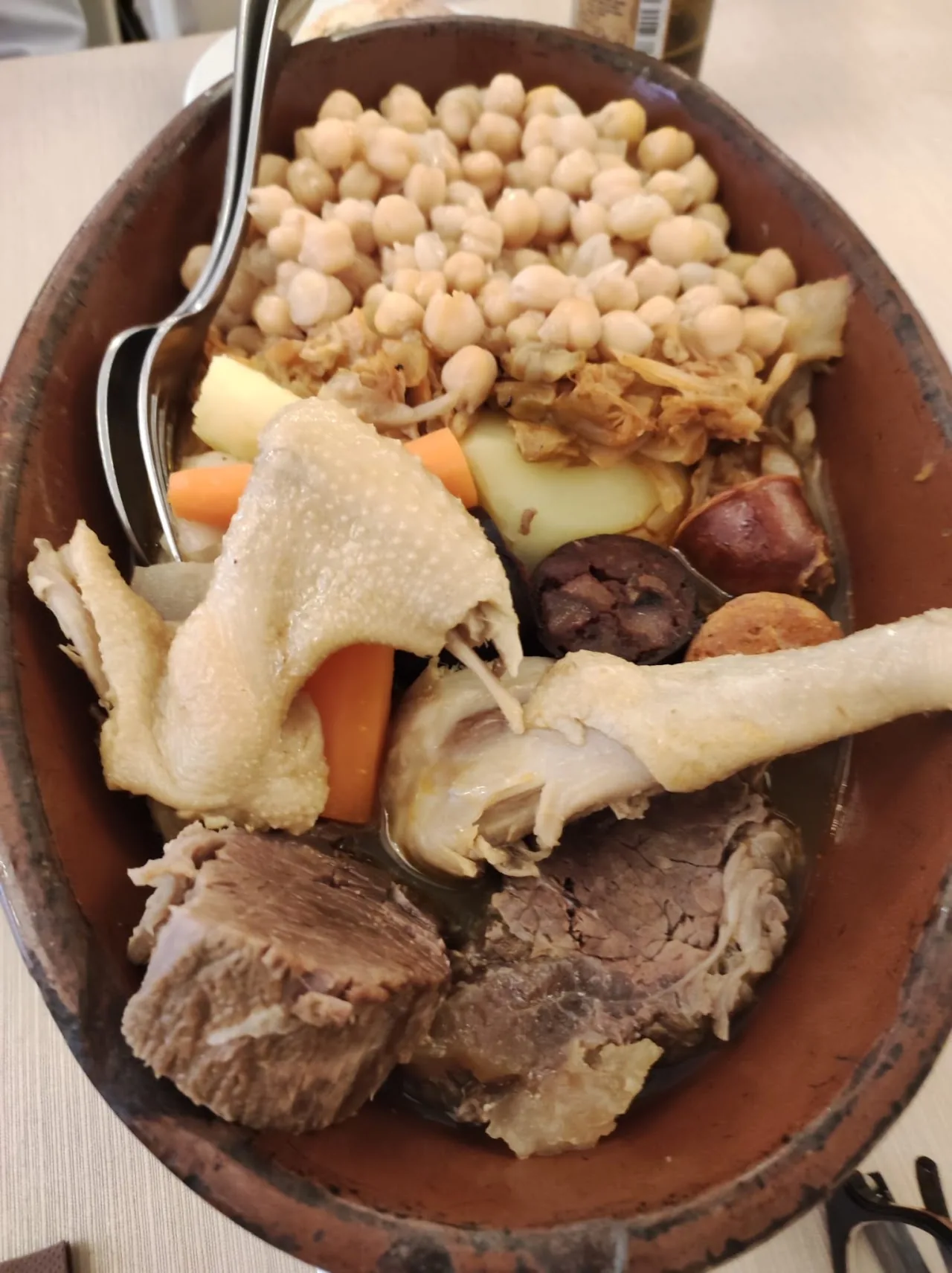 A clay pot of cocido stew with chickpeas and meat