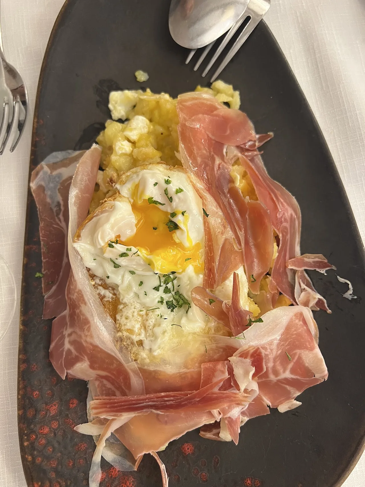 A baked egg dish wrapped in jamón