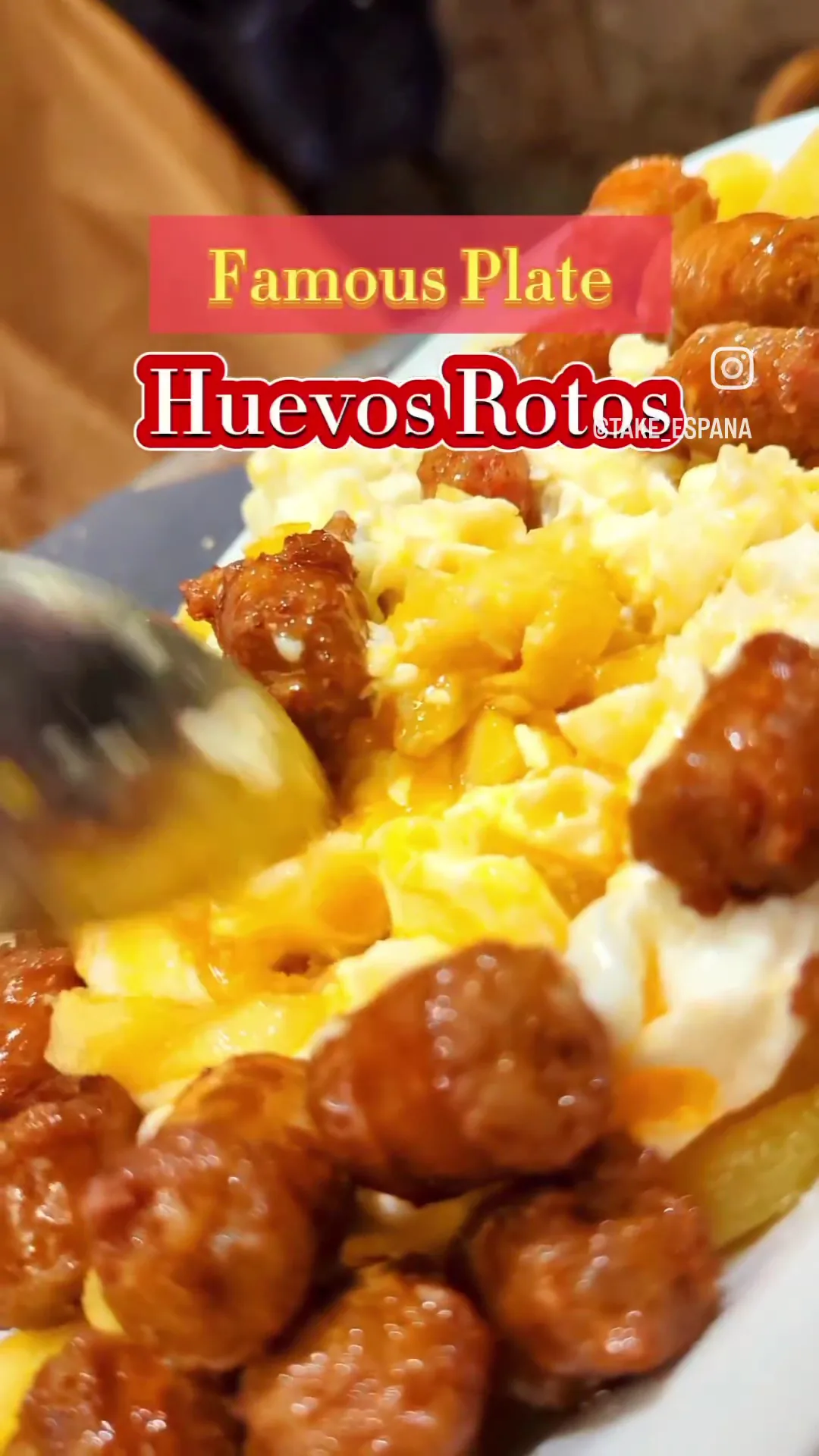 A plate of huevos rotos with fried potatoes and sausage