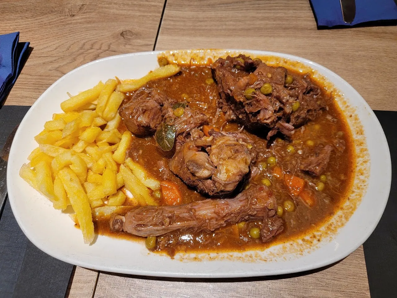 A meat and vegetable stew served with fries