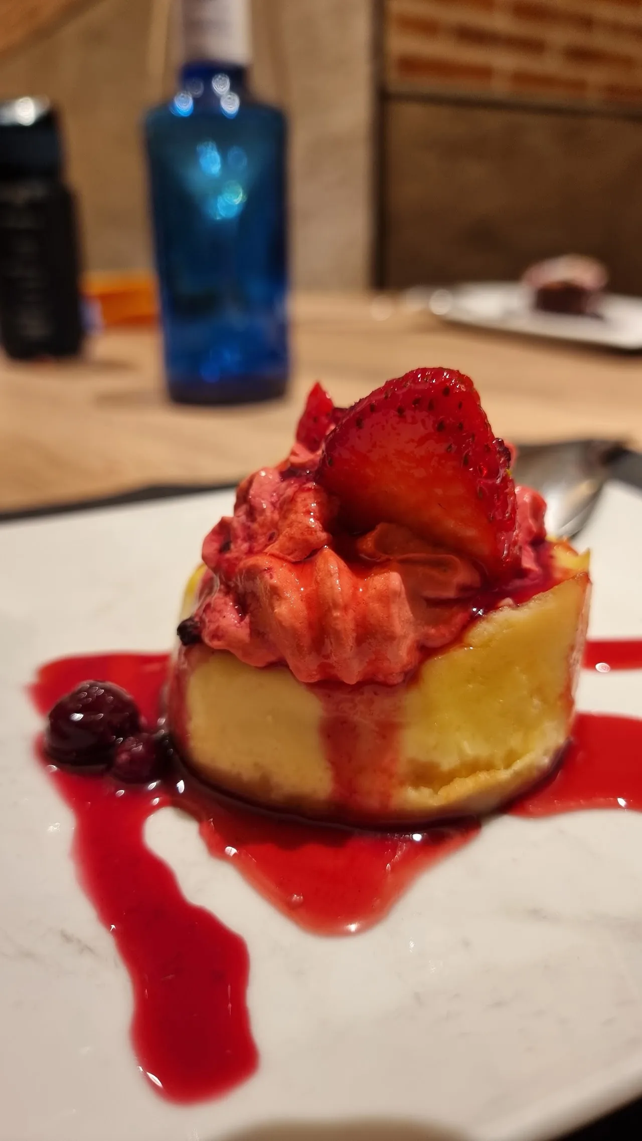 A small cheesecake topped with a fresh strawberry