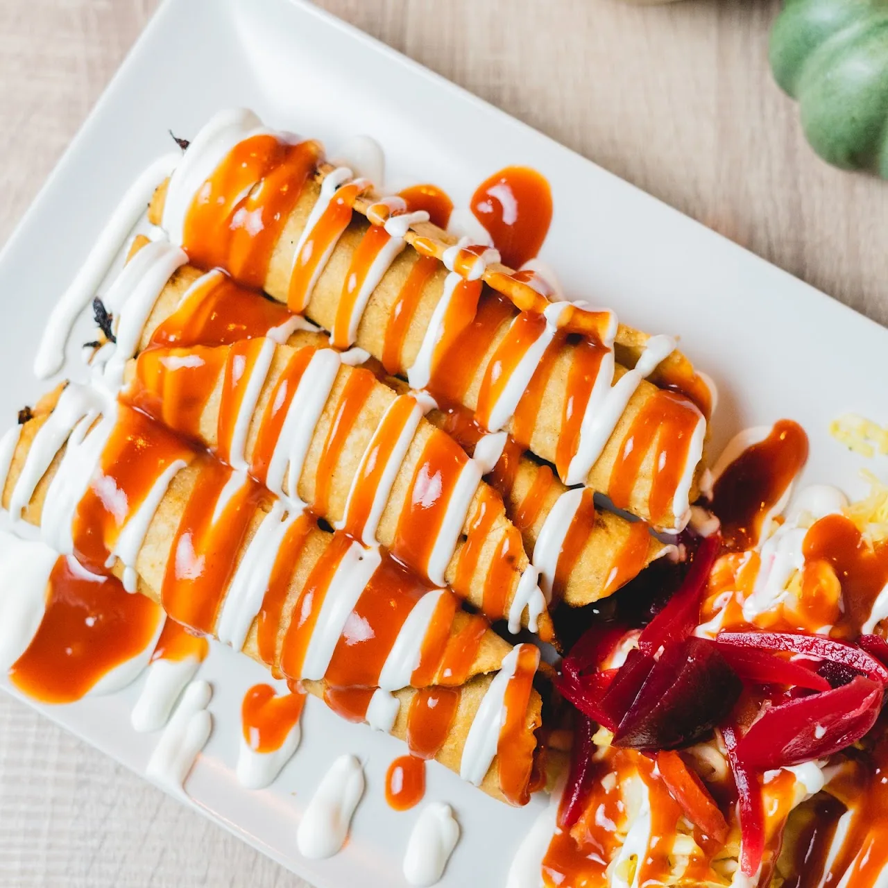 Sushi rolls drizzled with orange and white sauce