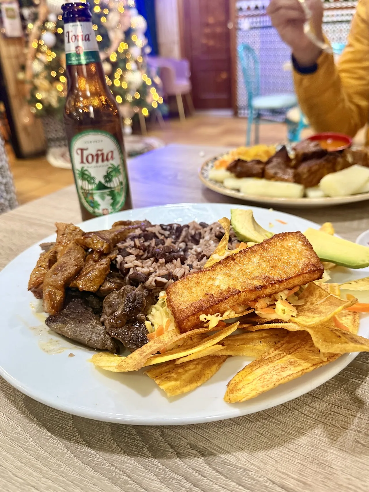 A plate of grilled meat with fried plantain chips