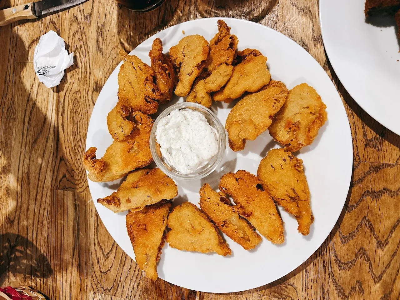 A plate of fried chicken pieces around a central dip