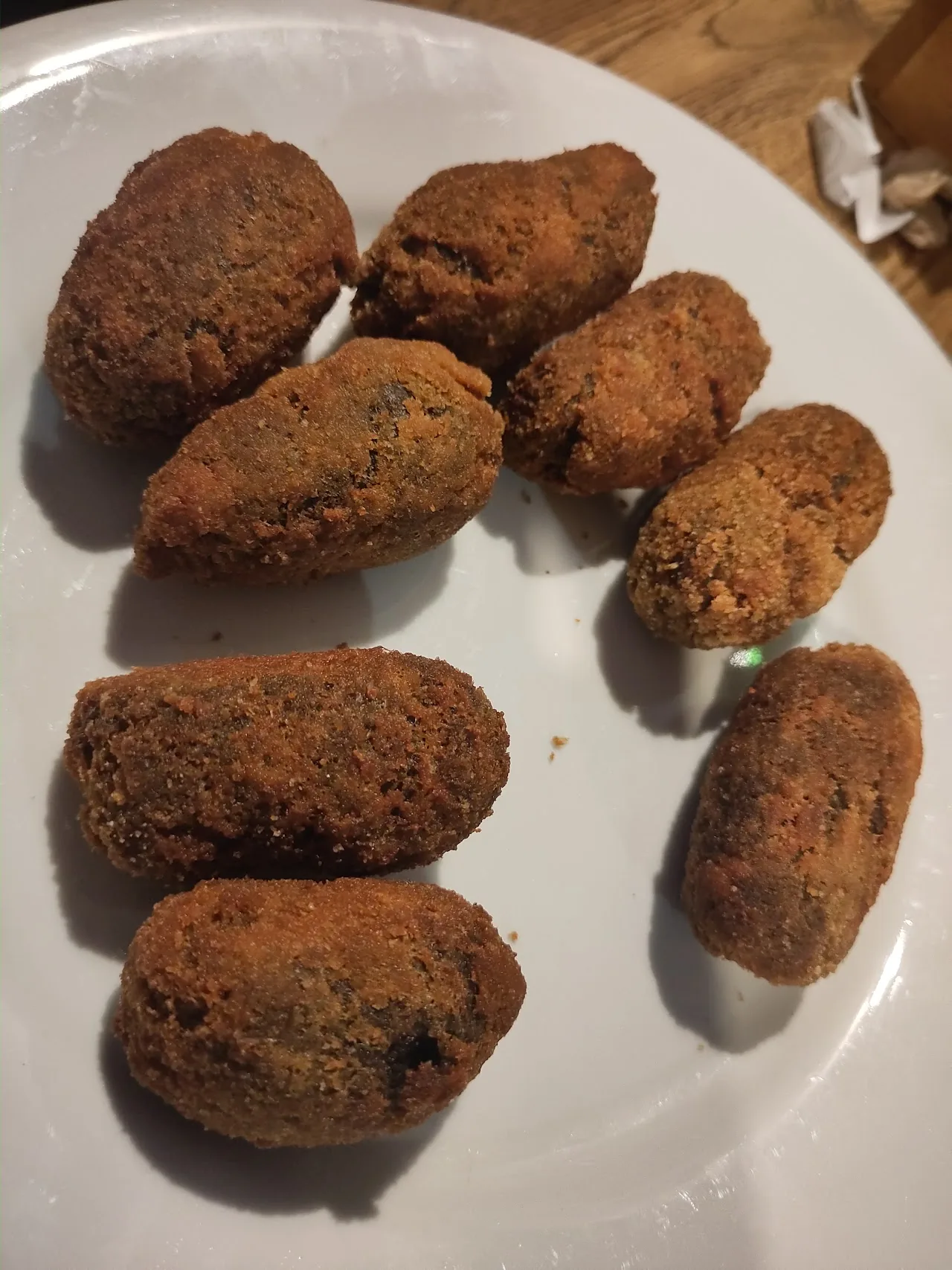 Six breaded croquettes on a plate