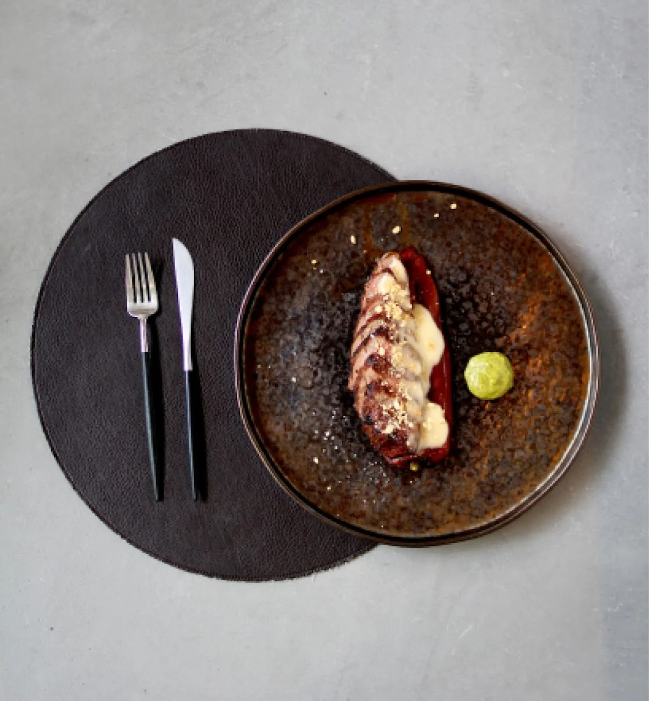 A plate of octopus with a sauce drizzle