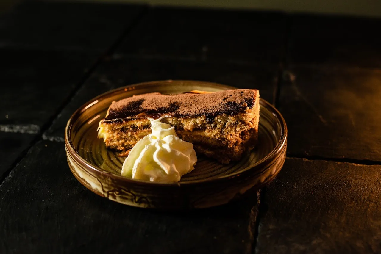 A slice of layered dessert cake with cream