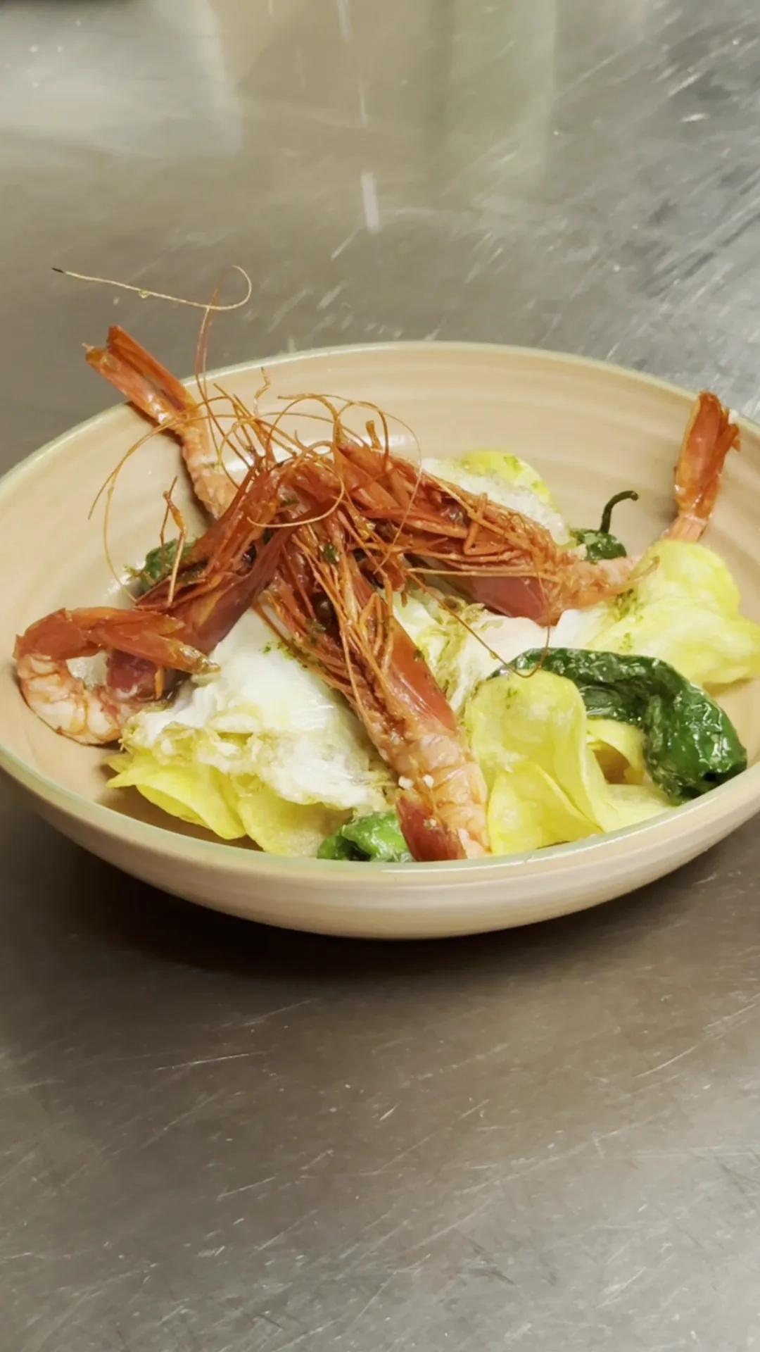 A bowl of prawns over salad greens