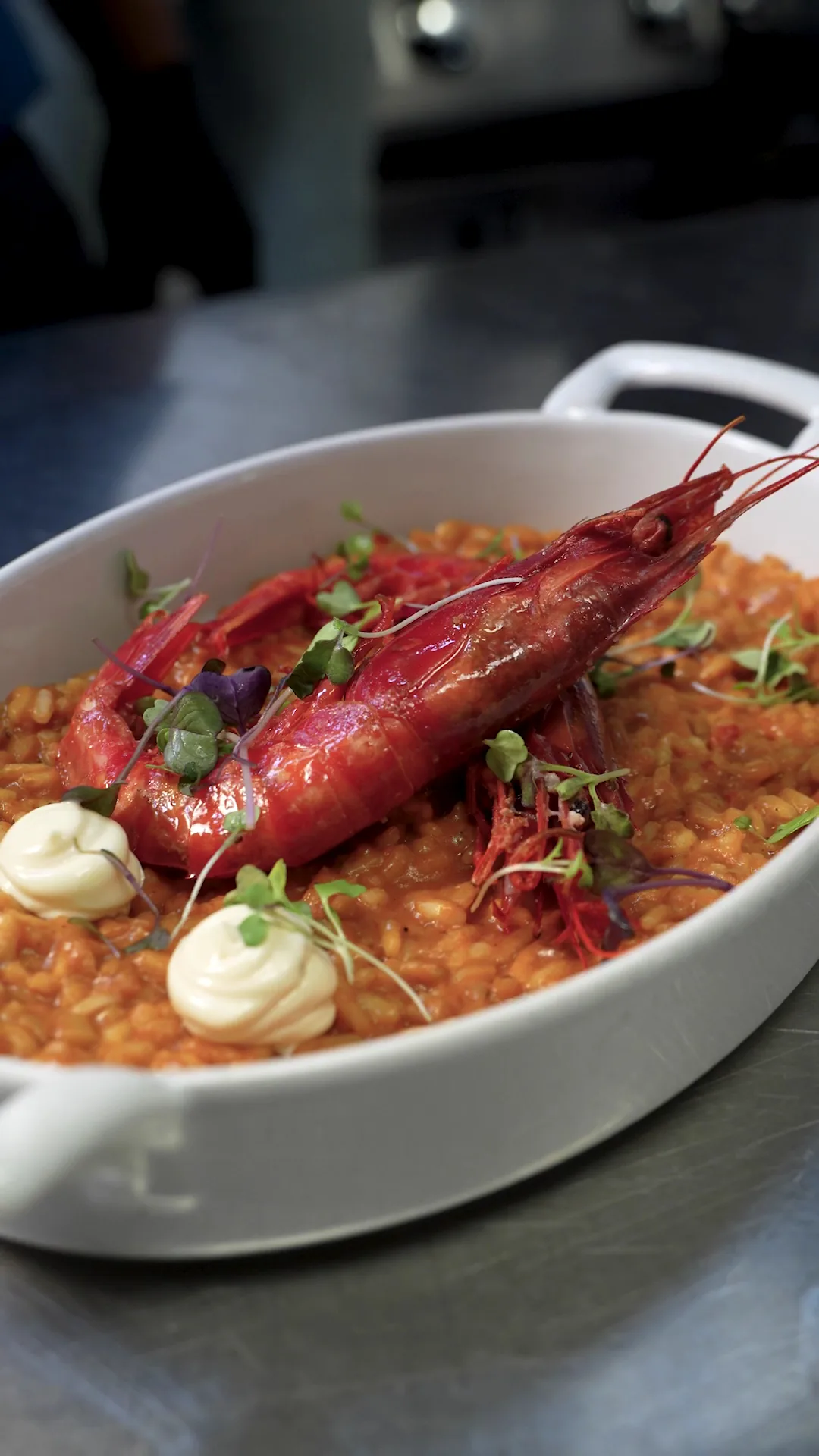 A pan of rice topped with a large prawn