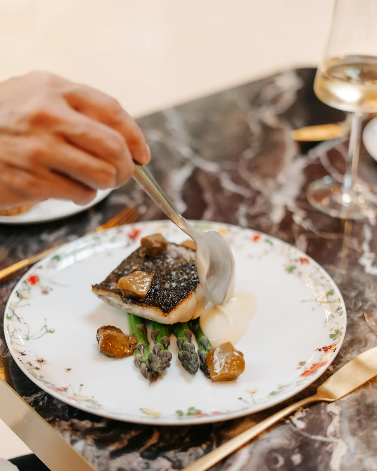 A plated fish dish with grilled asparagus and mushrooms