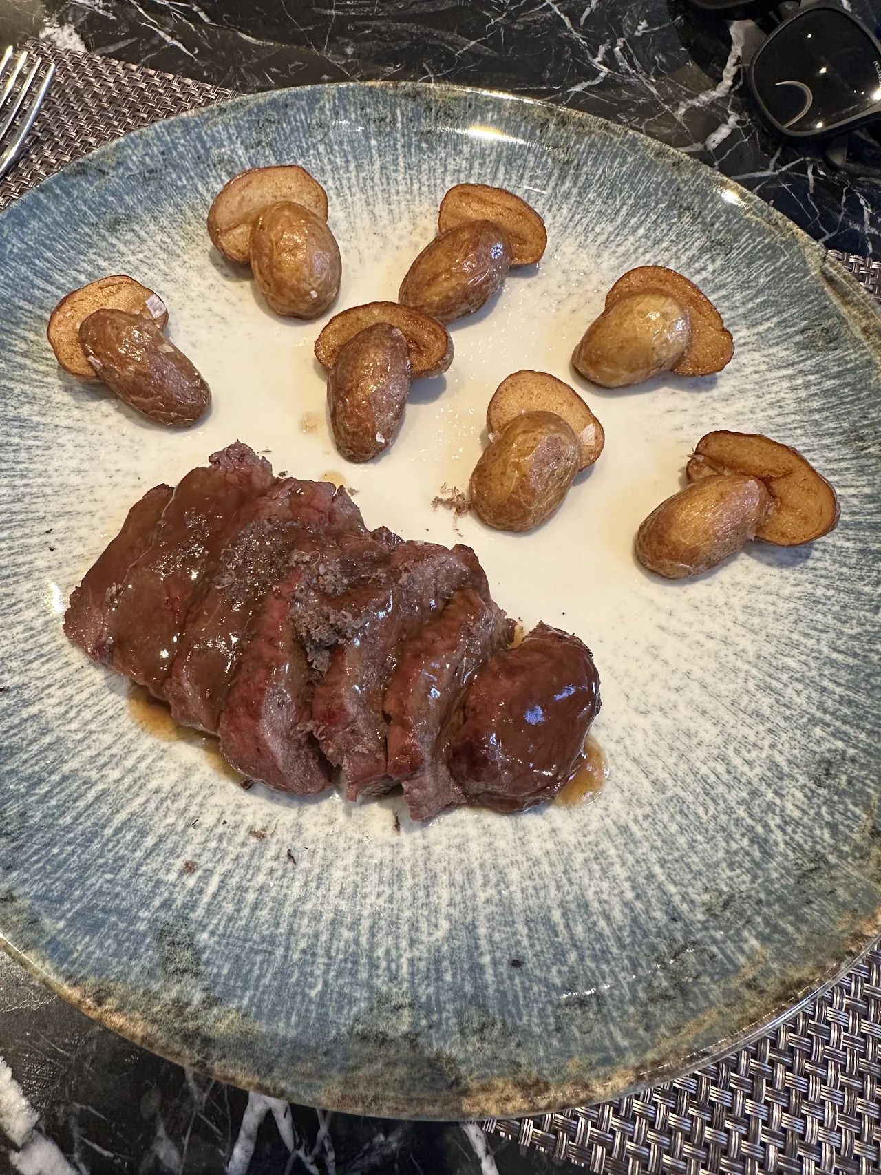 A plate of sliced steak with sautéed mushrooms