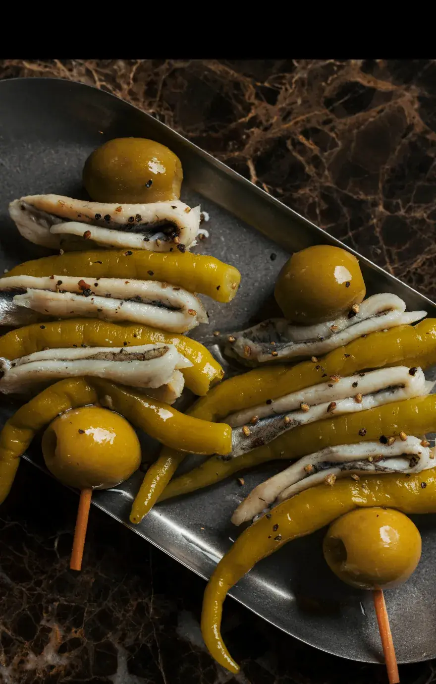 Skewered anchovy fillets, olives, and pickled green peppers (gilda) on a metal serving tray, Madre Taberna Moderna