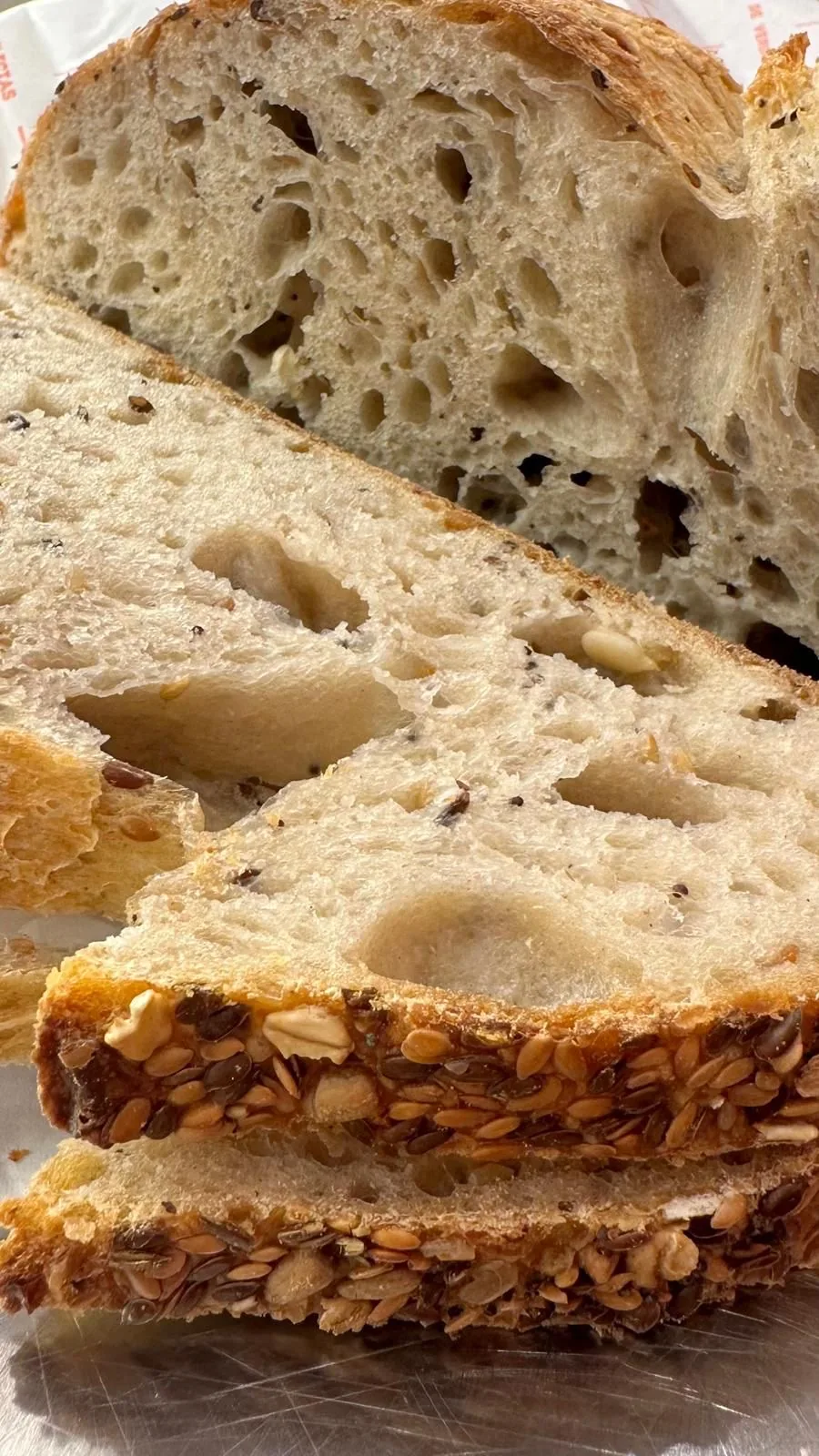 A sliced loaf of crusty artisan bread showing an open crumb