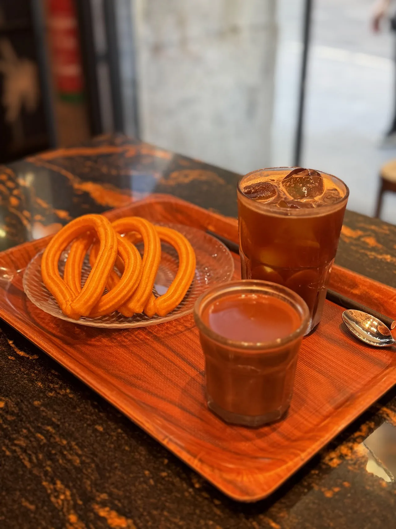 Twisted fried churros with two cups of chocolate dipping sauce
