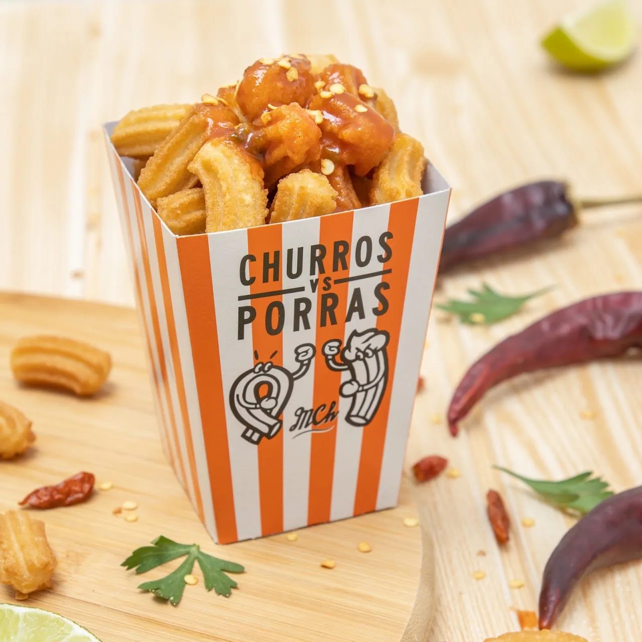 A paper cone of fried churros with dried chilies alongside