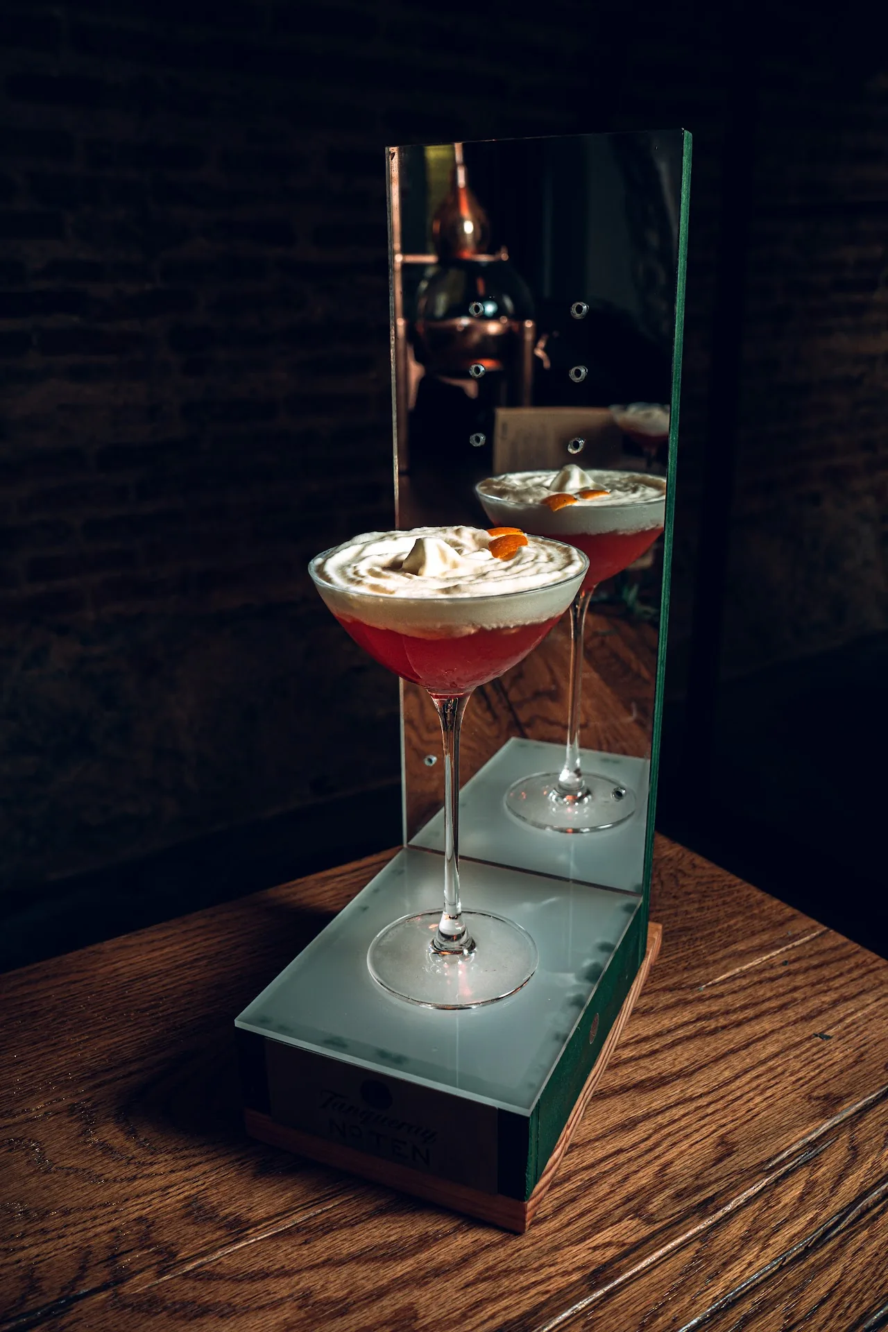 Two martini-style cocktails reflected in a mirrored tabletop display