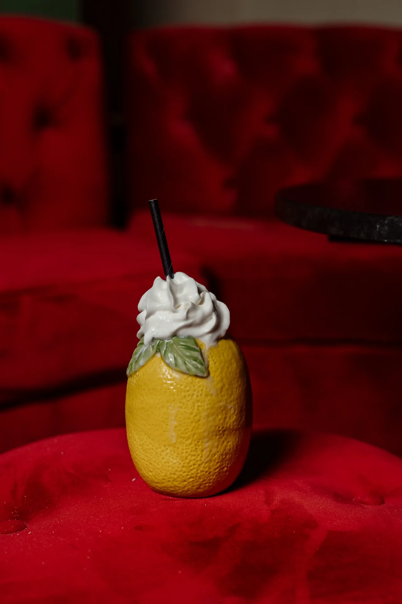A cocktail served in a hollowed citrus fruit topped with whipped cream