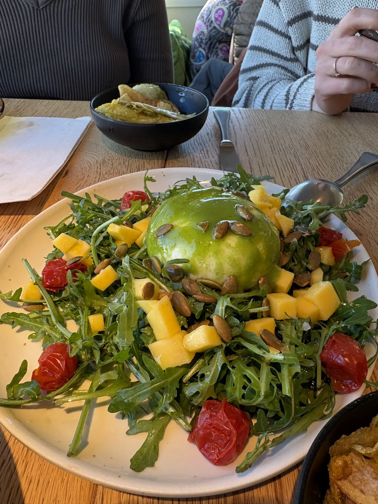 Rocket salad with burrata, mango, cherry tomatoes and seeds