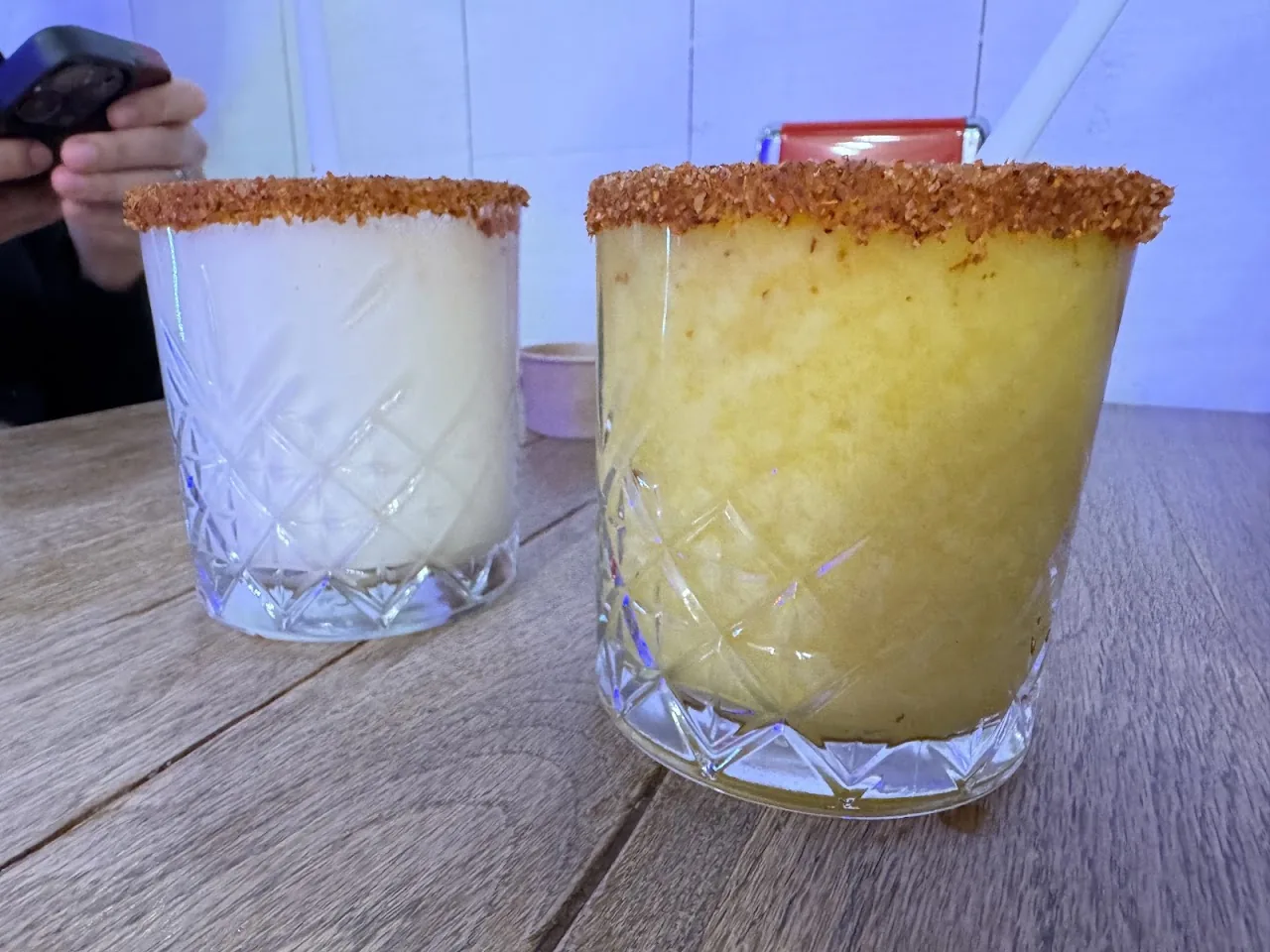 Two frozen margaritas with tajin-rimmed glasses