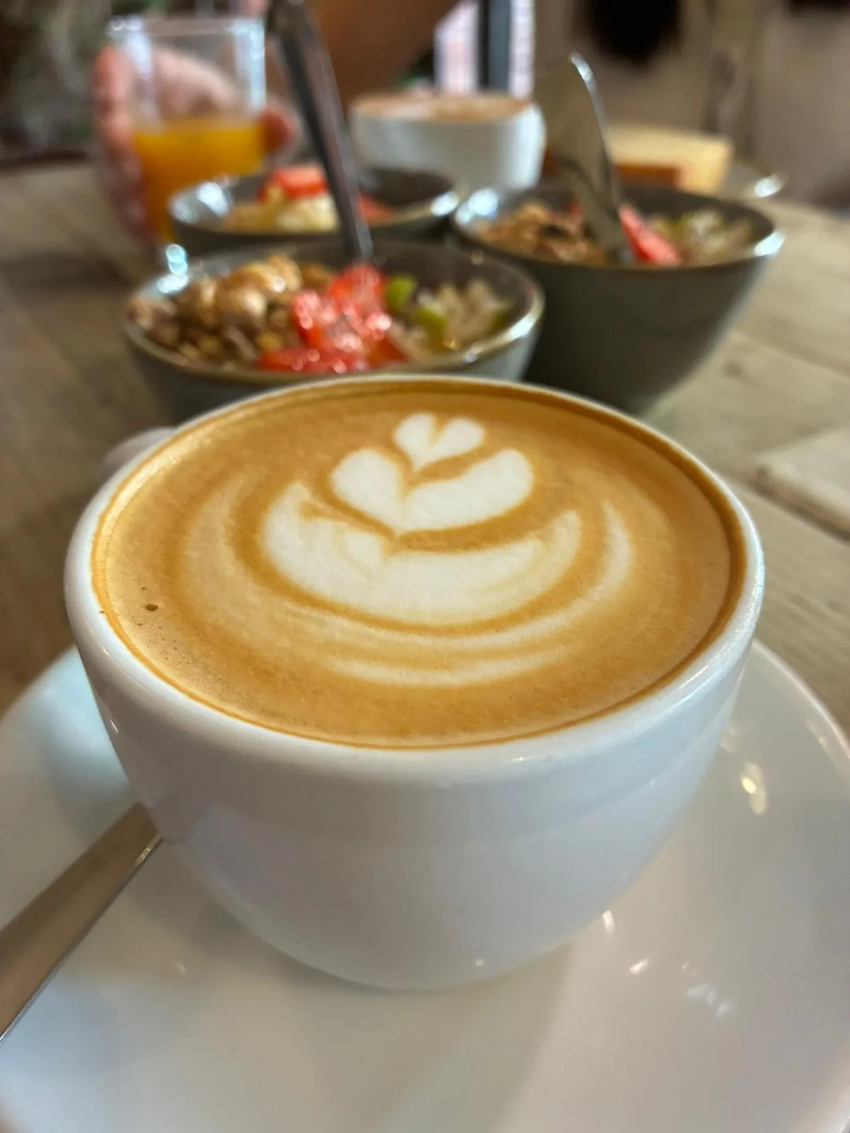 A cappuccino with latte art on a wooden table