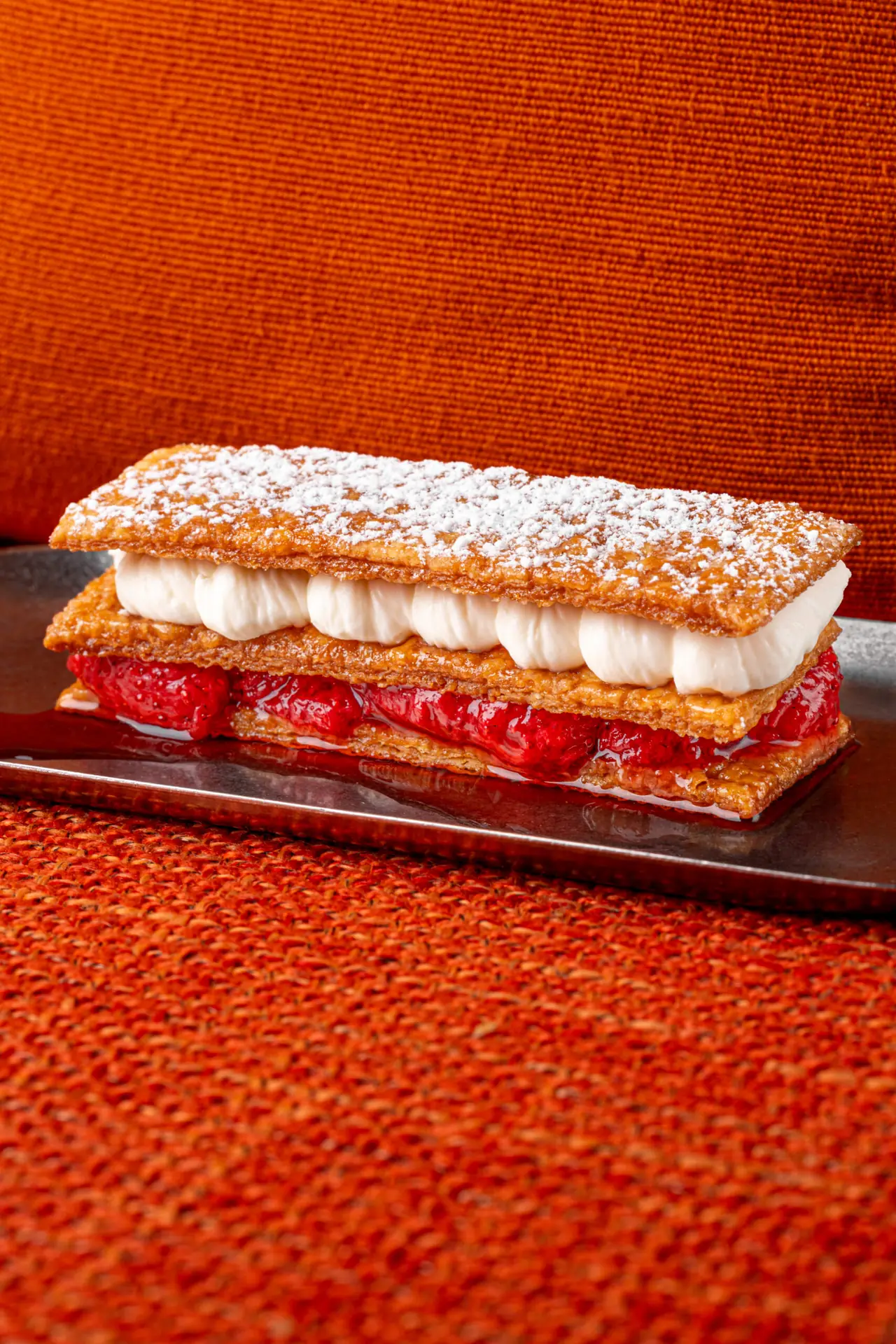 Layered mille-feuille pastry dusted with powdered sugar, filled with cream and strawberries, Manda Huev0s