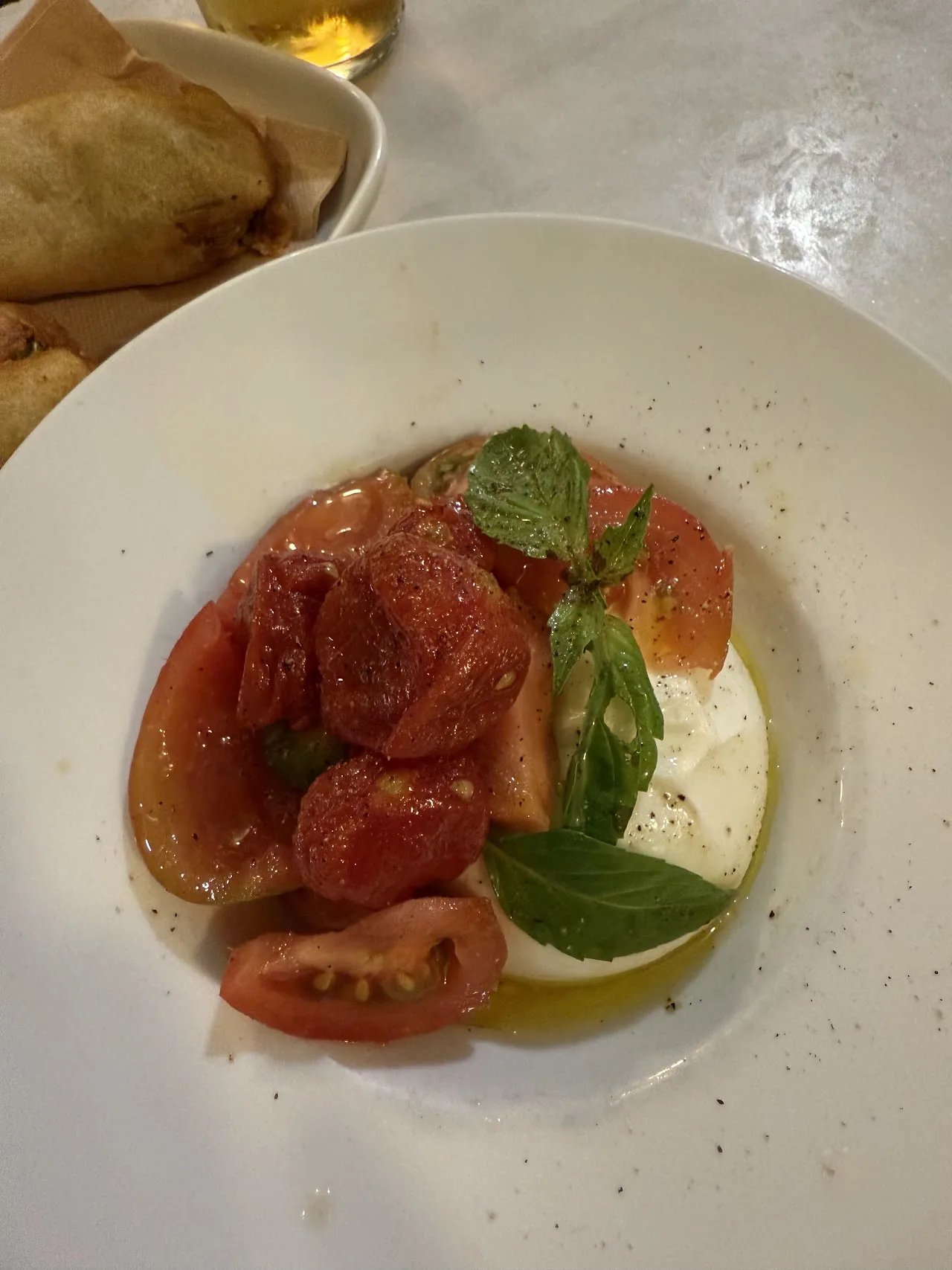 Sliced tomatoes and burrata with olive oil and basil