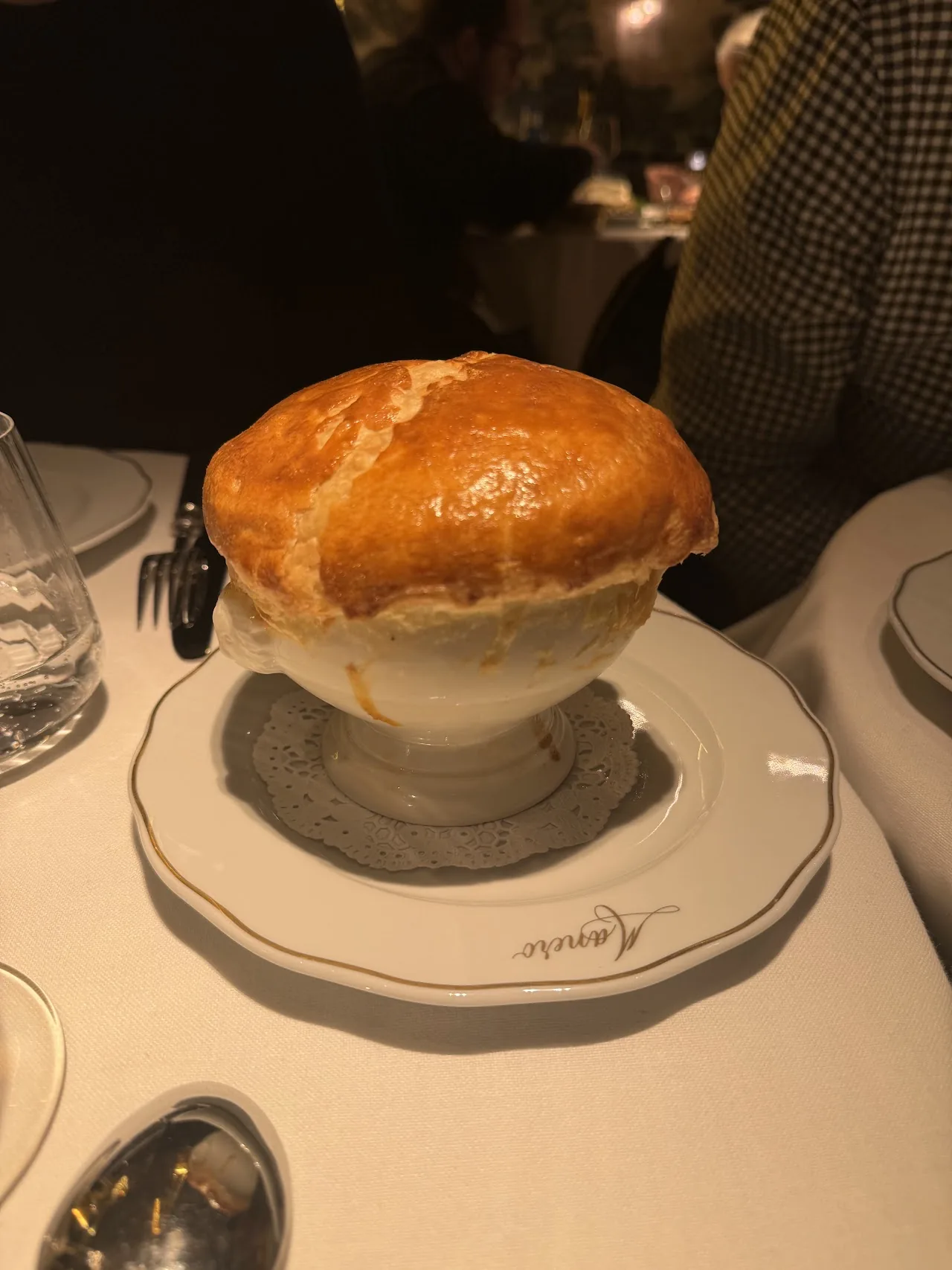A golden puff pastry pot pie in a white bowl